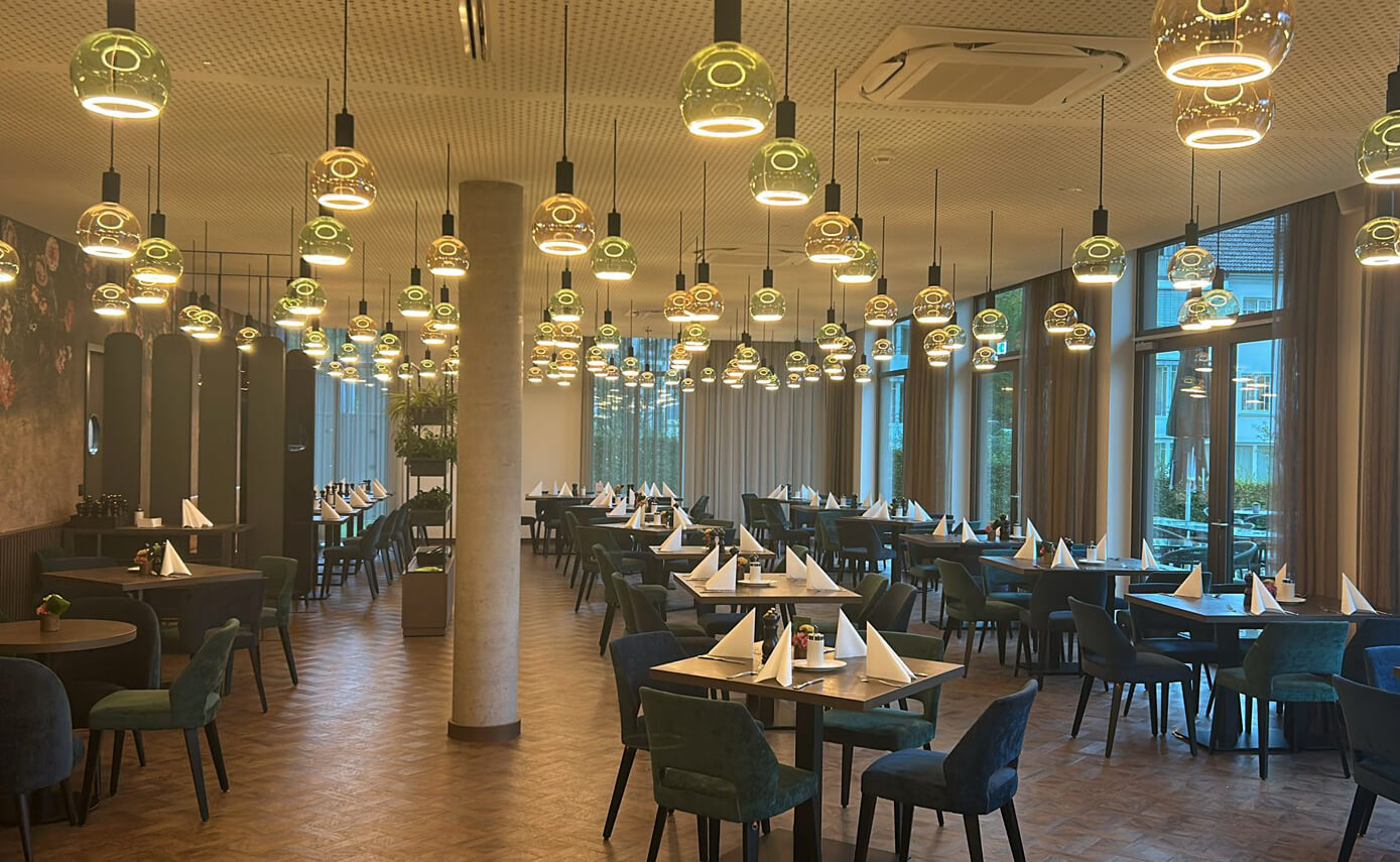 Referenzbild des Karlshotels in Sigmaringen, Frühstücksraum mit einer Vielzahl an Floating Leuchtmitteln