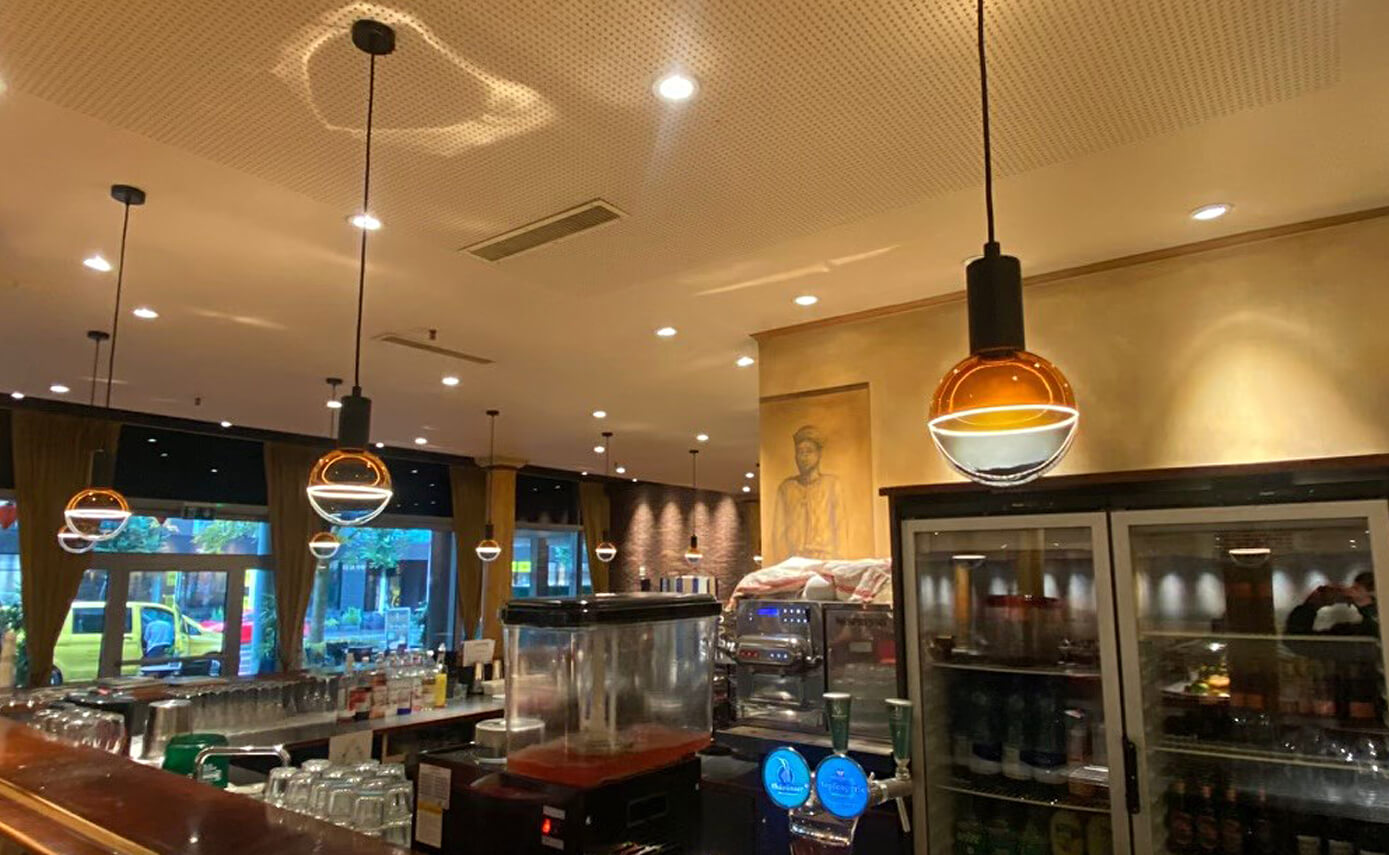 Referenzbild des Restaurant Han in Zug, Illusion Leuchtmitteln in blau-gelb hängend über einer Theke