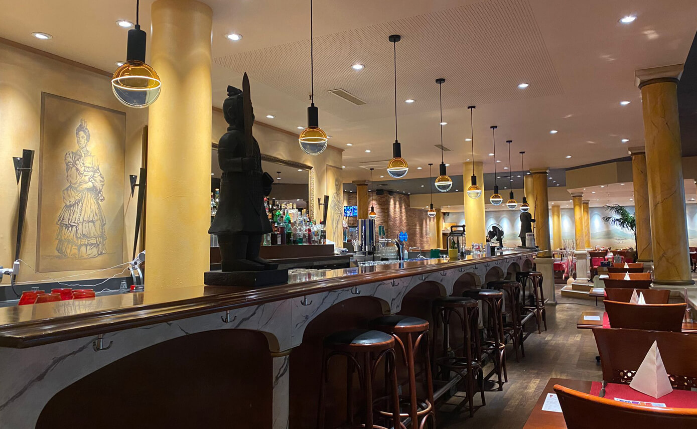 Referenzbild des Restaurant Han in Zug, Illusion Leuchtmitteln in blau-gelb hängend über einer Theke