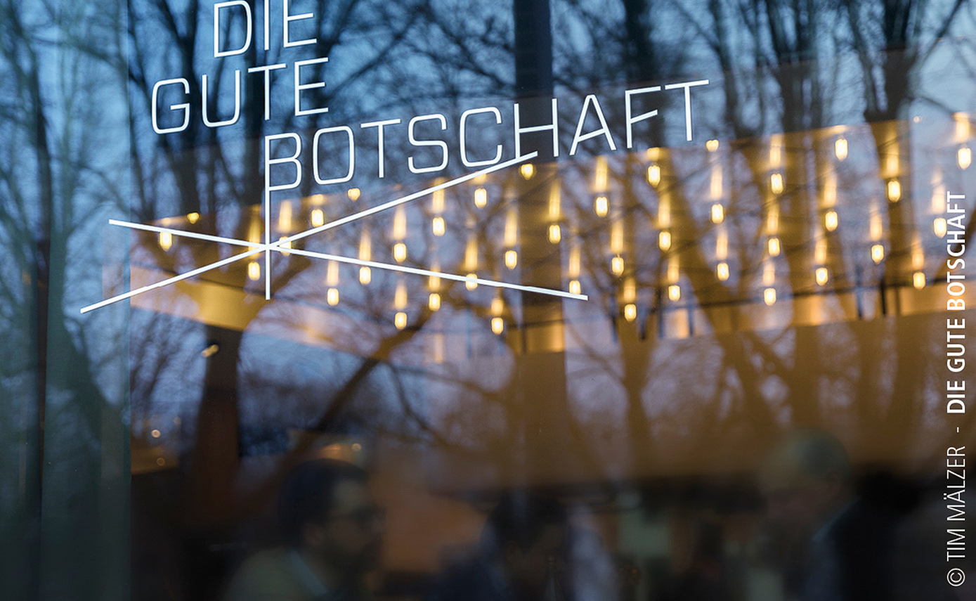 Referenzbild des Restaurants die gute Botschaft in Hamburg, Blick nach innen durch Fenster mit vielen Leuchtmitteln an der Decke