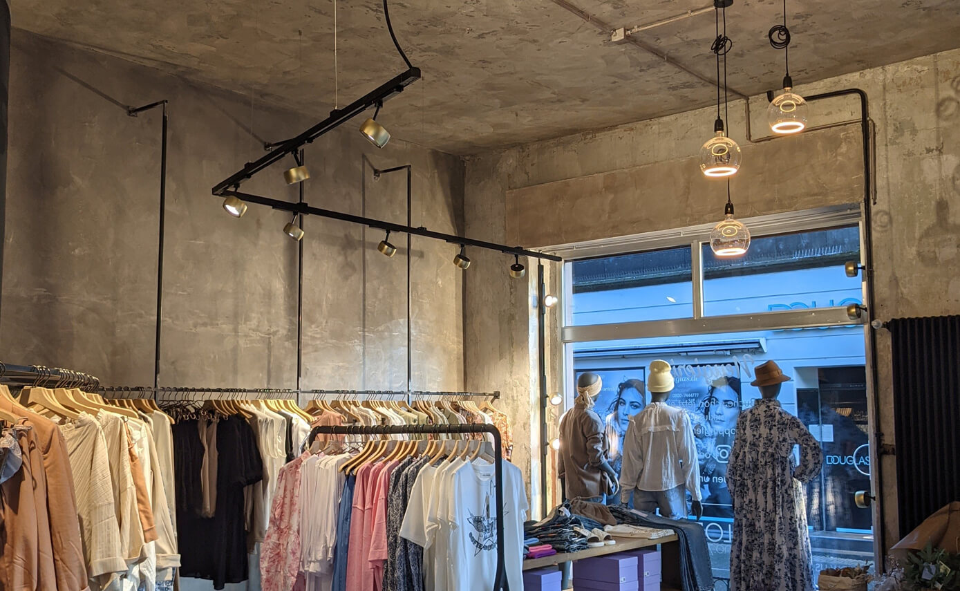 Referenzbild vom Scola Raumkonzepte in Andernach, Bekleidungsgeschäft mit Schaufenster und Floating Leuchtmitteln